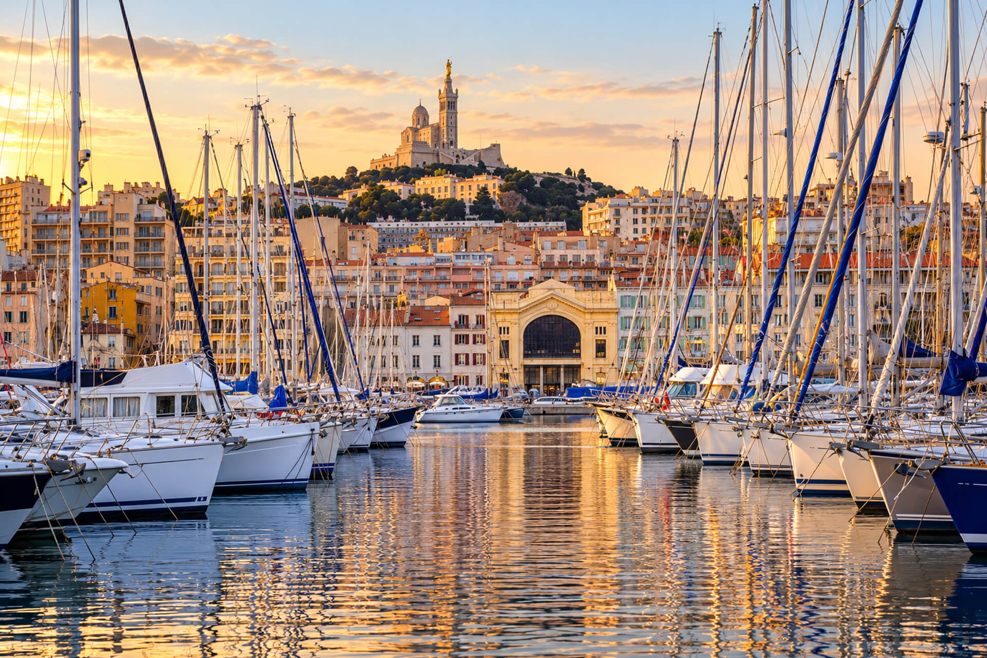 Le Vieux-Port à l’heure dorée, voiliers à quai et Notre-Dame de la Garde sur la colline