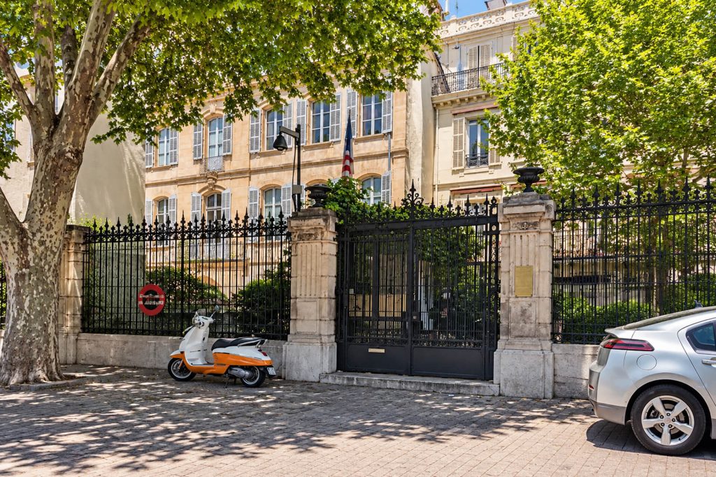 Grille et façade du consulat général des États-Unis à Marseille, sous les platanes