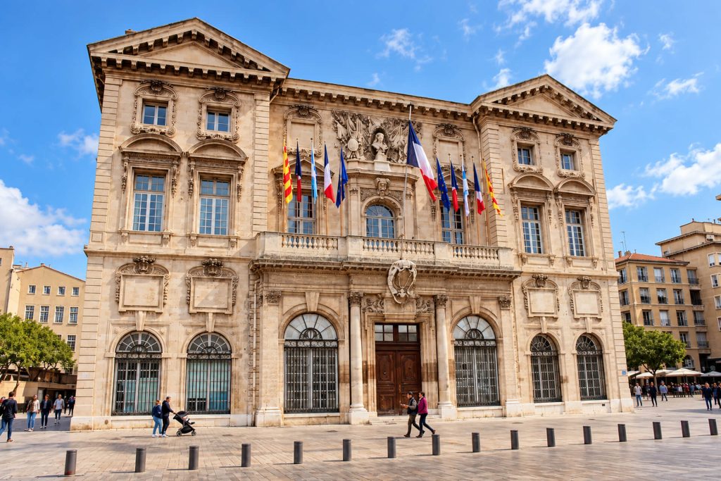 Façade baroque de l’hôtel de ville de Marseille et ses drapeaux, quai du Port