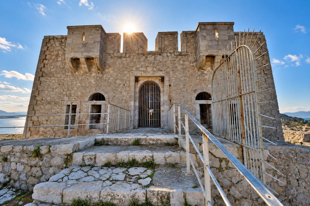 Tour de Pomègues en pierre avec sa porte grillagée et ses créneaux, au soleil